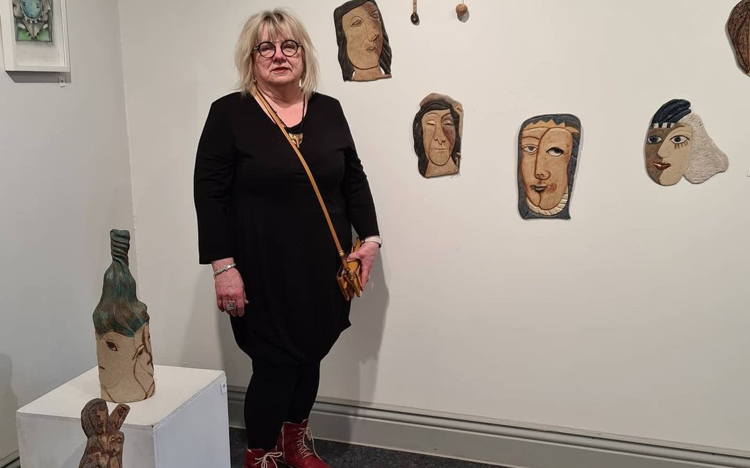 Maija Kantanen teostensa äärellä. Kuvassa etualalla vasemmalta lähtien teokset Läheiset, Perhe on paras, Sykeröllä, Ajatonta Aikaa III ja Maijan oikealla puolella seinällä Lähipiiri-sarja Perttu, Ylevä Nainen, Tukka Tuulessa, Iristyttö, Kunkku, Aatu, Bertta ja Inka.